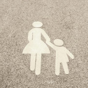 Outline of lady holding childs hand in the sand